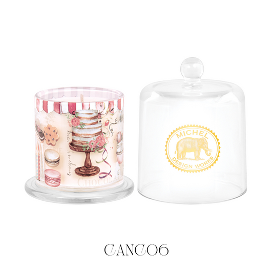 Birthday Buttercream Cloche Candle, featuring a bell-shaped glass covering. Lifting the cloche releases a delightful aroma of buttery vanilla with hints of coconut and chocolate, drizzled with caramel. This soy blend candle is designed to enhance any celebration or setting