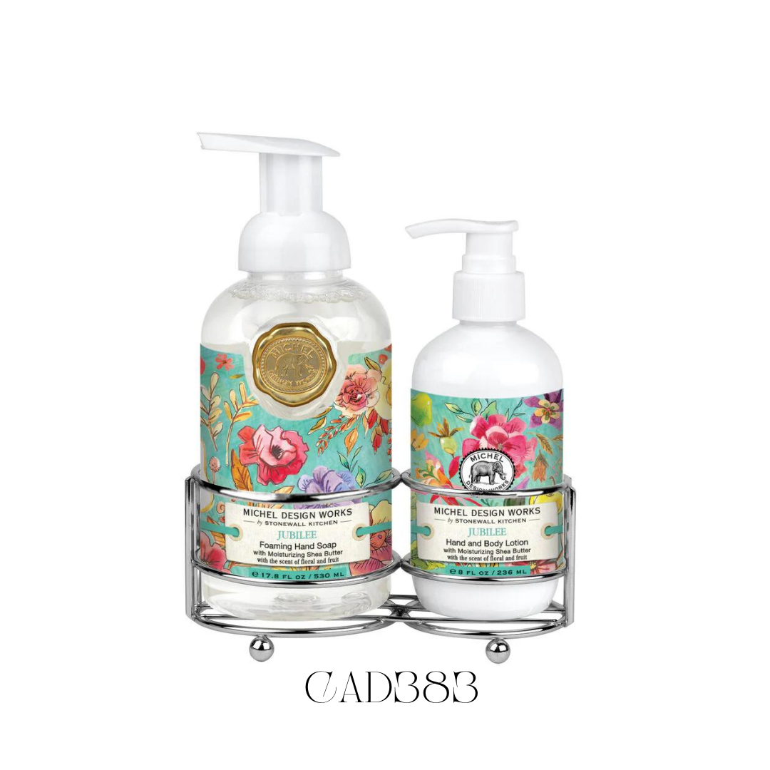 Hand Care Caddy Jubilee featuring a foaming hand soap and a rich hand and body lotion, both with whimsical notes of fruits and florals. Set in a stylish silver-toned caddy with a painterly design of blooms and produce against a turquoise background, perfect for adding a vibrant touch to kitchen counters or guest bathrooms