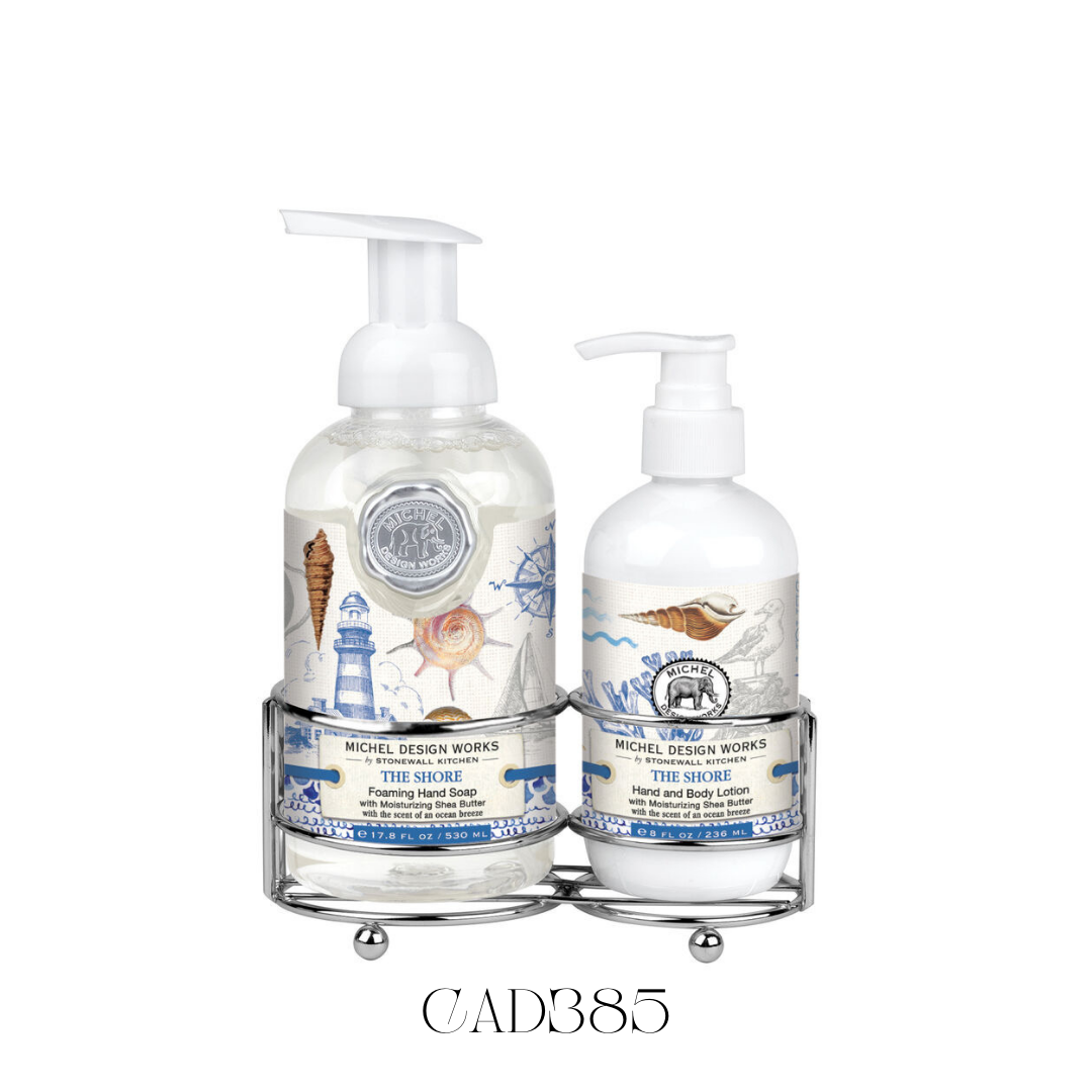 Hand Care Caddy The Shore featuring a foaming hand soap and a rich hand and body lotion, both with evocative scents reminiscent of a day at the beach. Set in a silver-toned caddy with classic coastal imagery in shades of ocean blue, perfect for adding a touch of seaside charm to kitchen counters or guest bathrooms