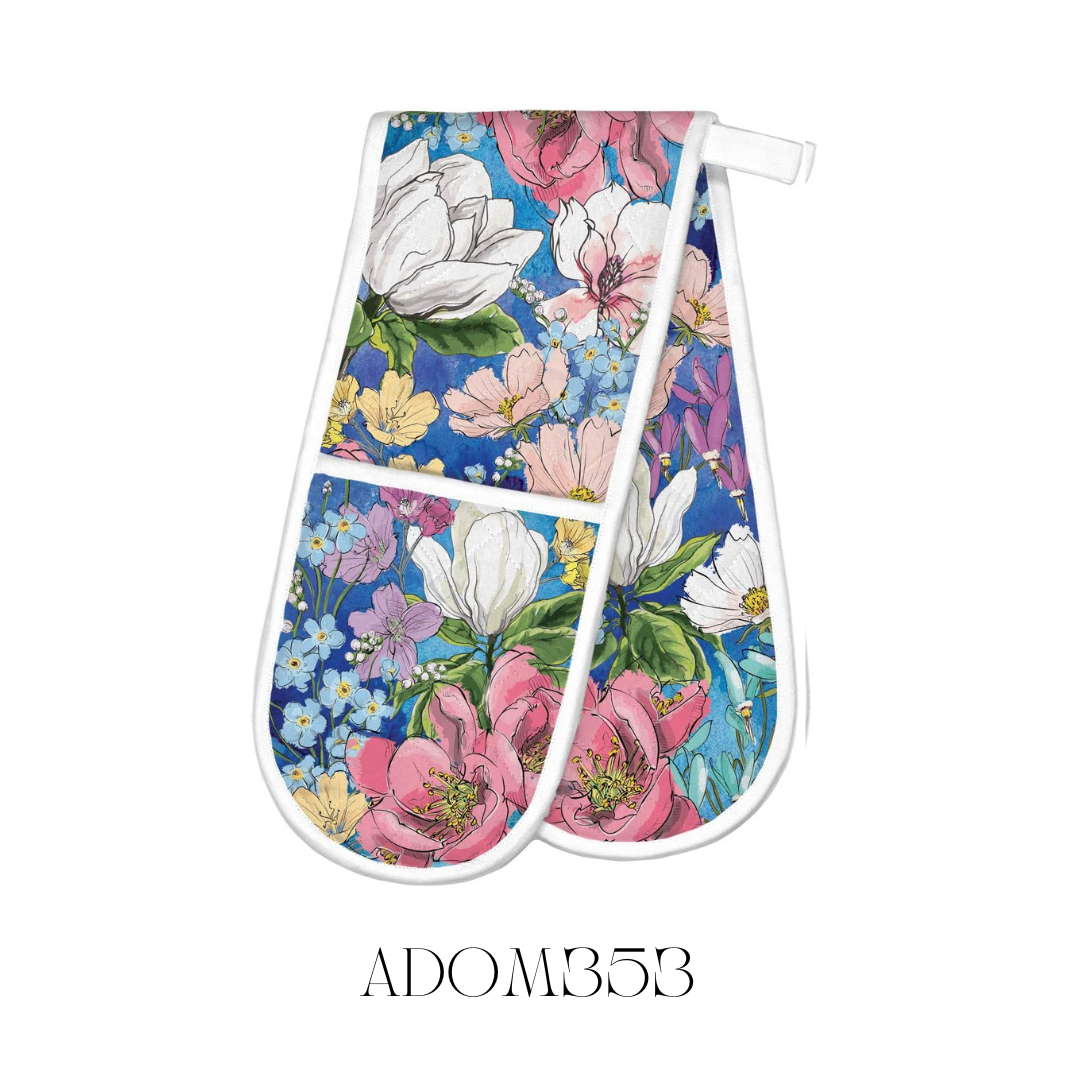 Magnolia Double Oven Mitt laid flat, crafted from 100% cotton with a cotton/poly fill for extra thickness and protection. This oven mitt features a beautiful magnolia design and measures approximately 85 x 27.75 cm, offering both style and safety in the kitchen