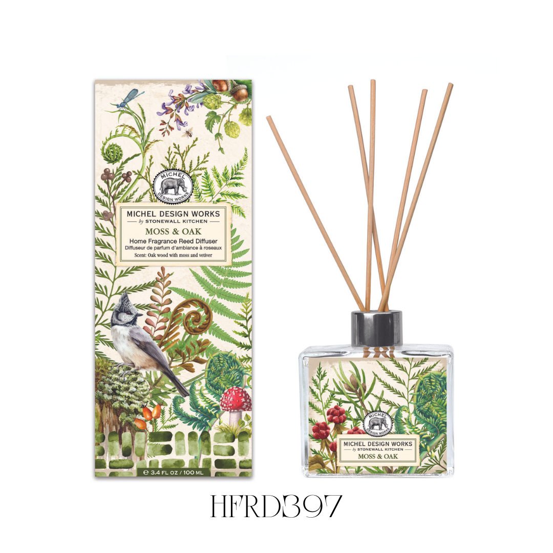 Moss and Oak Reed Diffuser displayed in a living space, showcasing the stylish glass decanter with lush artwork and eight reeds. The diffuser releases a tranquil blend of oak wood, moss, and vetiver, creating a serene woodland atmosphere in kitchens, bathrooms, or any room