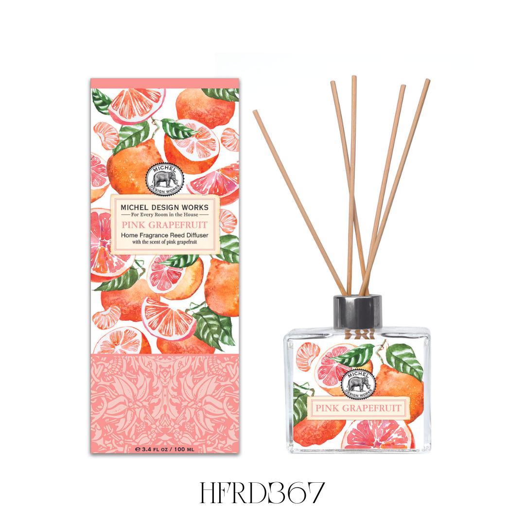 Pink Grapefruit Reed Diffuser displayed in a kitchen, showcasing the stylish glass decanter with printed artwork and eight reeds. The diffuser releases a vibrant blend of pink grapefruit, lime, and rose, adding a fresh and uplifting scent to any room